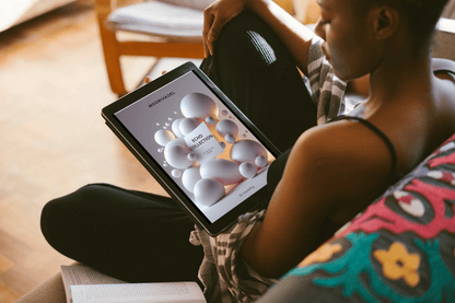 Person holding a tablet with 3D modelling course on it, sitting on a couch.