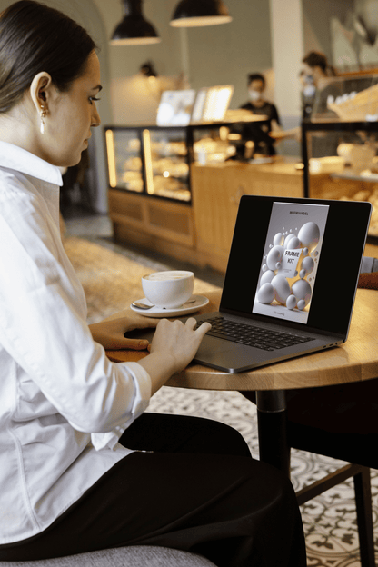 Woman using a laptop in a cafe with a cup of coffee on the table