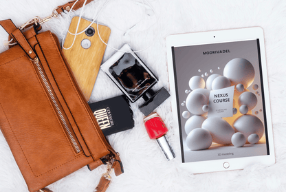 Brown leather wallet, phone, perfume bottle, nail polish, and tablet with a course on a white surface