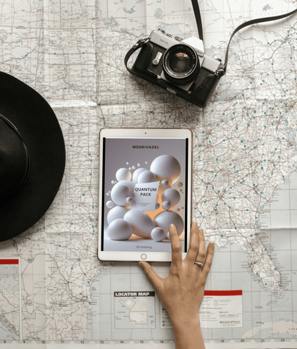 Person using a tablet on a map with a camera and hat nearby